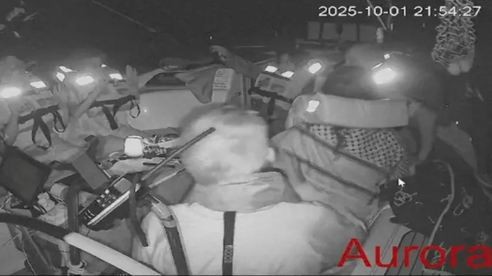 <i>لقطة شاشة من فيديو مباشر تُظهر أفراد الطاقم جالسين على متن سفينة أورورا المتجهة إلى غزة</i><br>&nbsp;
