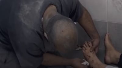 ابن فلسطيني ينظف قدم والدته بعد نجاتهما ..فيديو