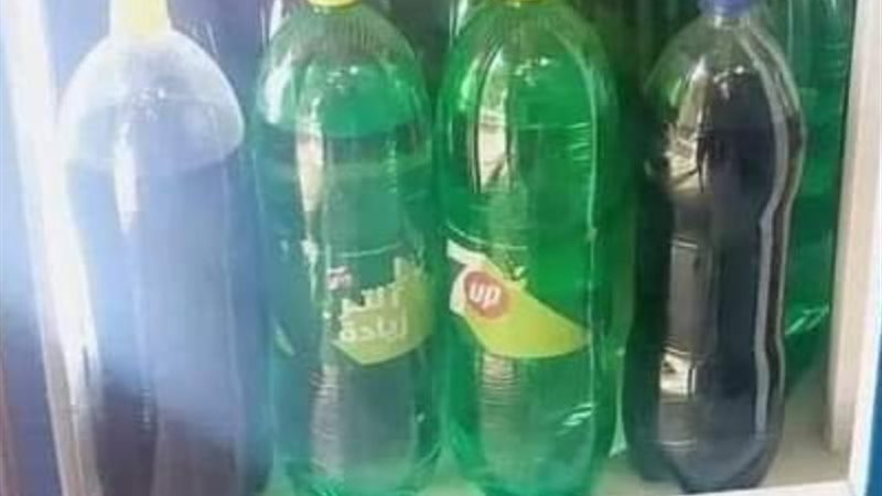 أحد البائعين يزيل ملصق أحد المشروبات الغازية لخداع المشتري