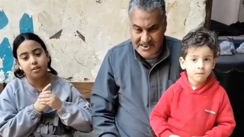 الأب يحمل نجله المصاب 