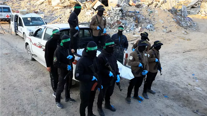 عناصر حماس يسلمون رفات رهينة إسرائيلي في وقت سابق 
