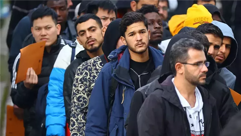 مهاجرون يصطفون أمام مركز استقبال طالبي لجوء في ألمانيا